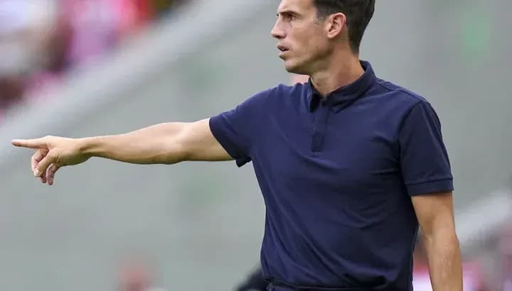 Entrenador dirigiendo instrucciones desde la línea de banda
