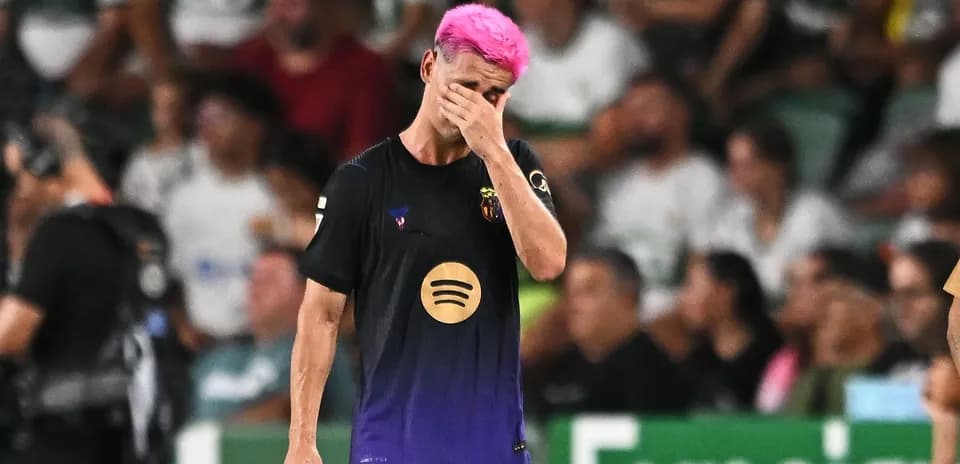 Jugador con cabello rosa caminando por el campo