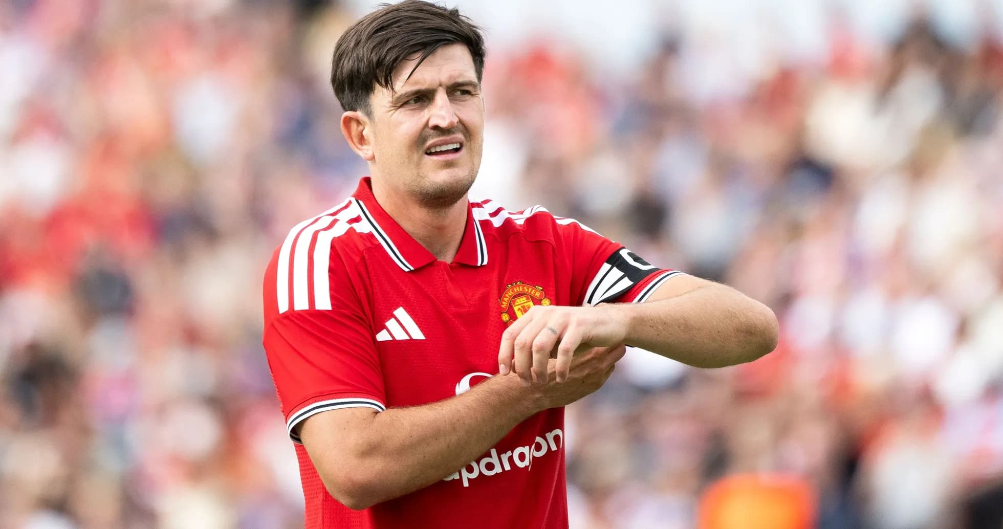 Jugador de Manchester United revisando su muñeca en el campo
