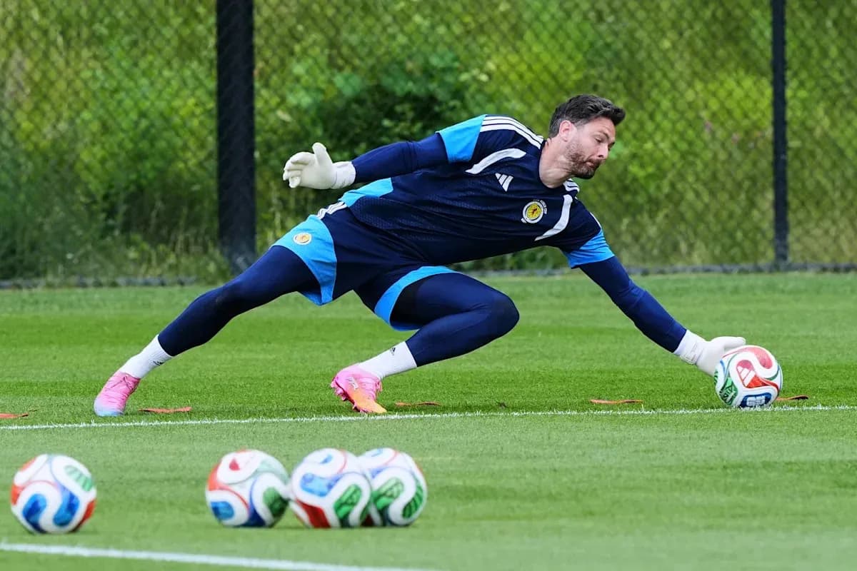 Portero entrenando y atrapando un balón en campo