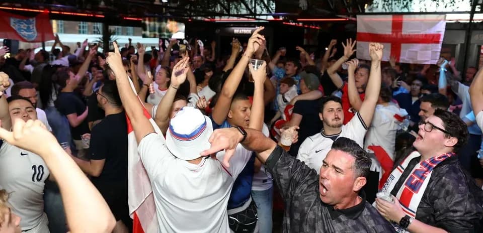 Aficionados animando en un bar durante partido