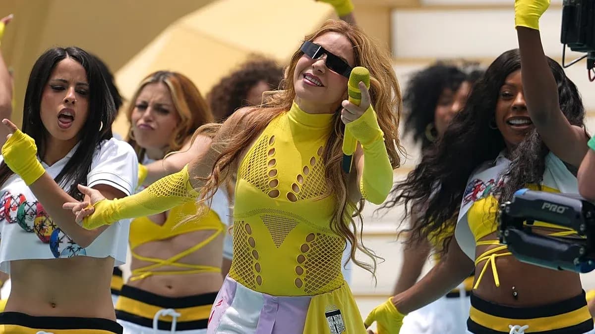 Artista con micrófono actuando junto a bailarinas