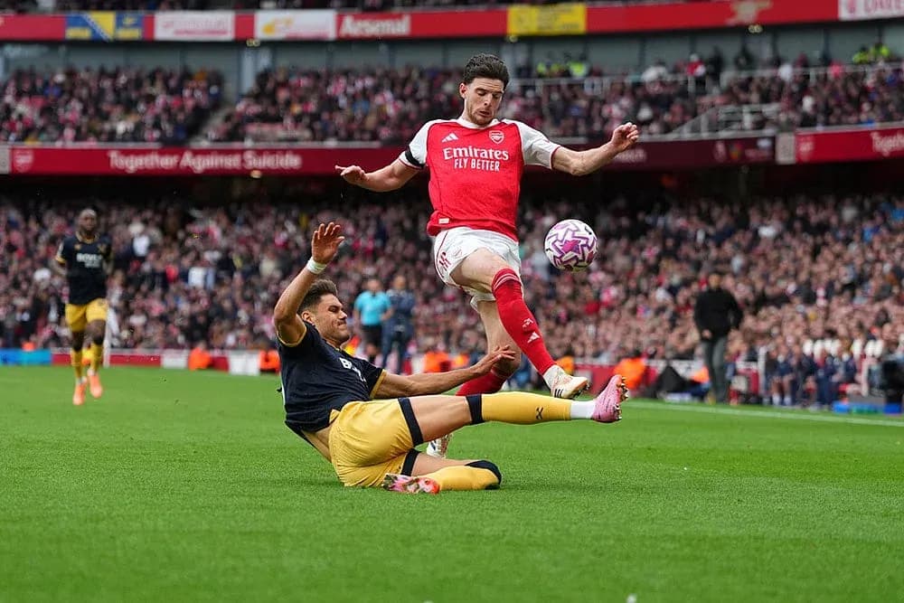 Un jugador de Arsenal salta sobre un rival