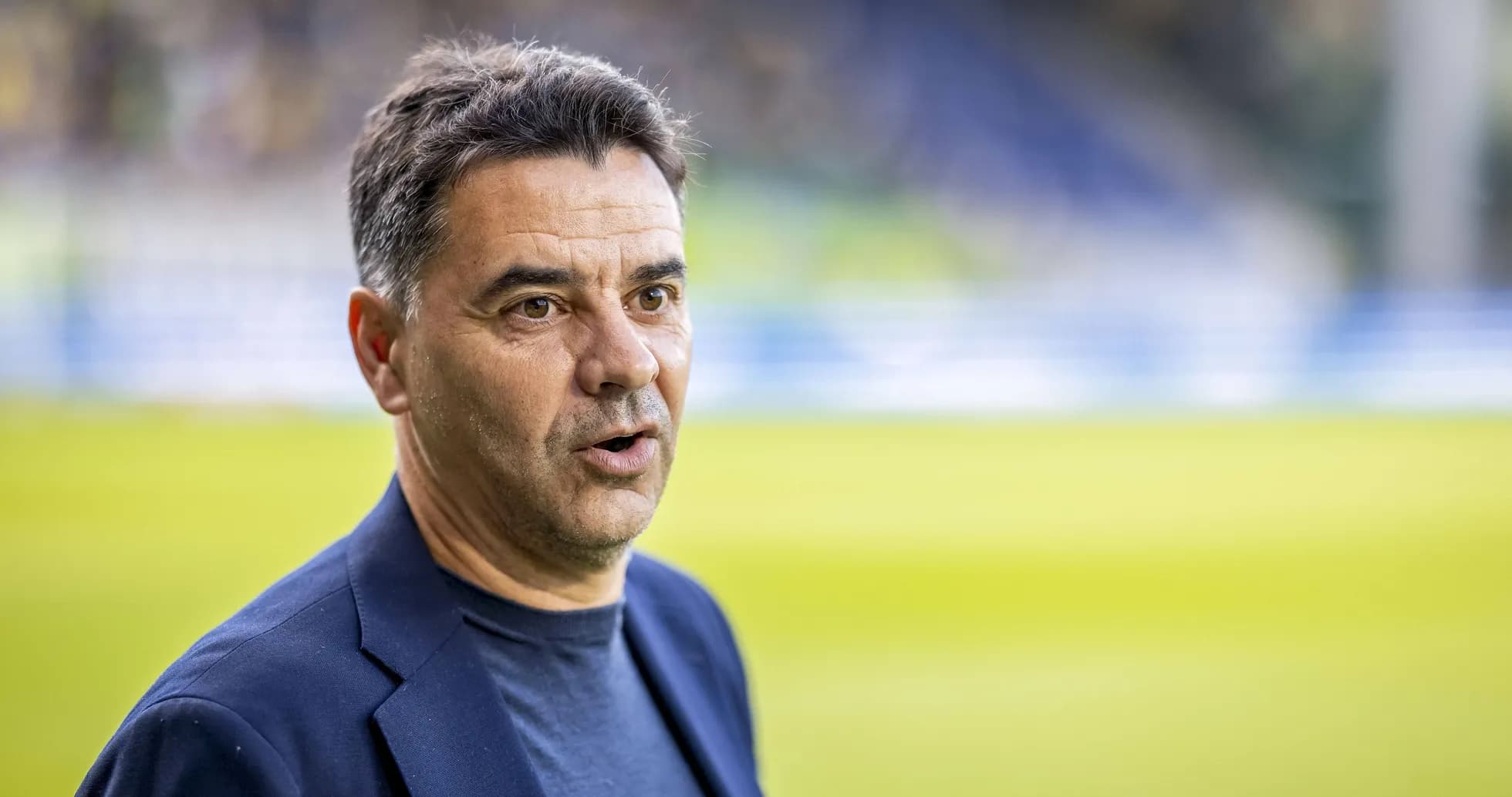 Entrenador hablando en el campo de fútbol