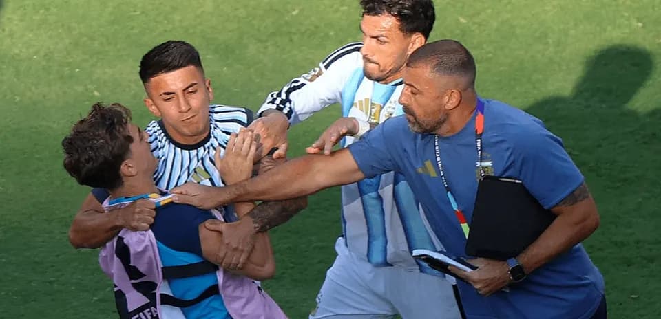 Jugadores y entrenador separando a dos jugadores en conflicto