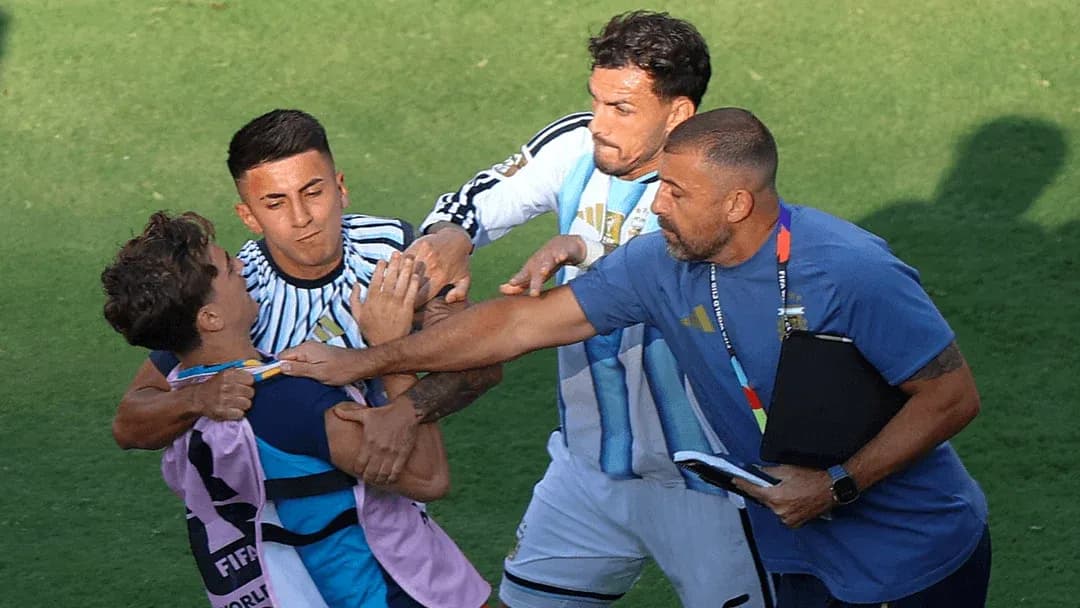 Jugadores y entrenador separando a dos jugadores en conflicto
