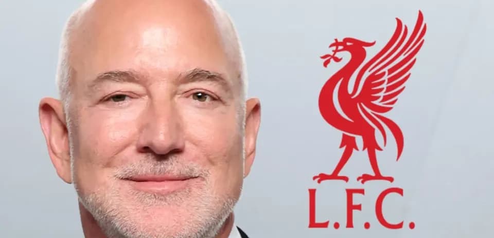 Persona sonriente con logo de Liverpool F.C. detrás