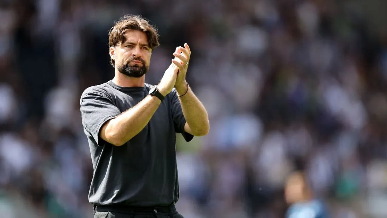 Entrenador aplaudiendo en el campo durante el partido