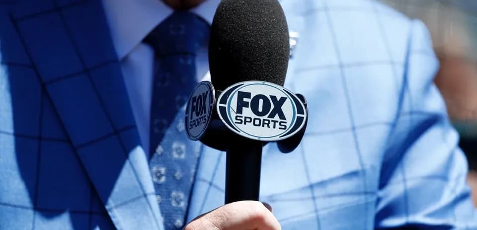 Mic with FOX Sports logo held by presenter