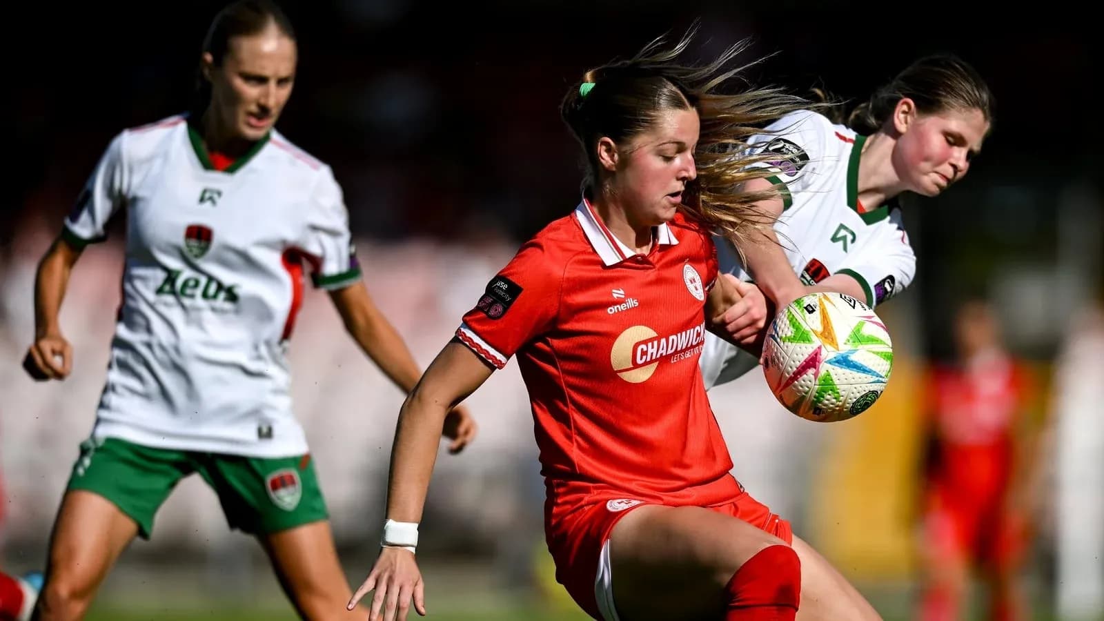 Jugadoras compitiendo por el balón en partido de fútbol