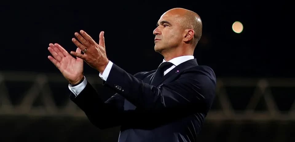 Entrenador aplaudiendo en la banda del estadio