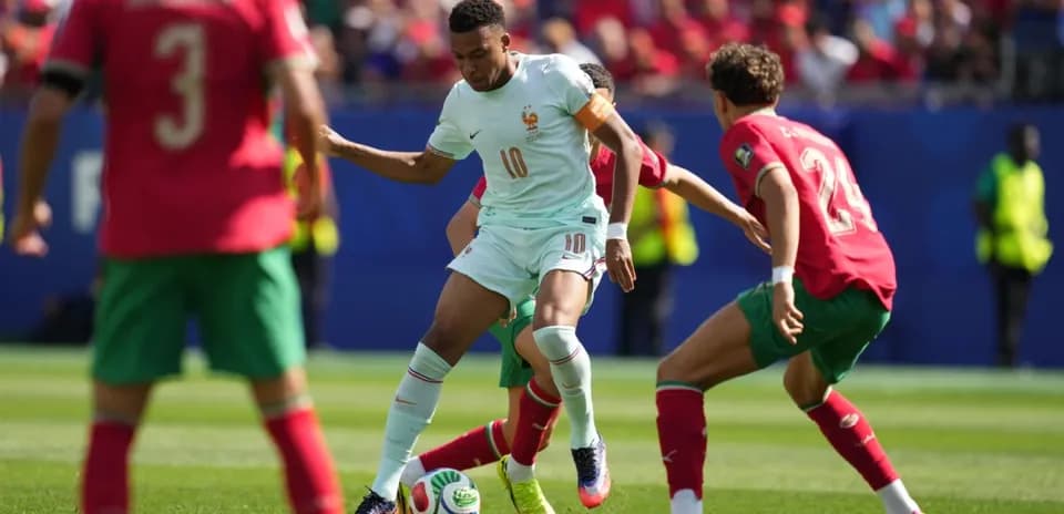 Jugador de Francia enfrentando a dos defensores marroquíes