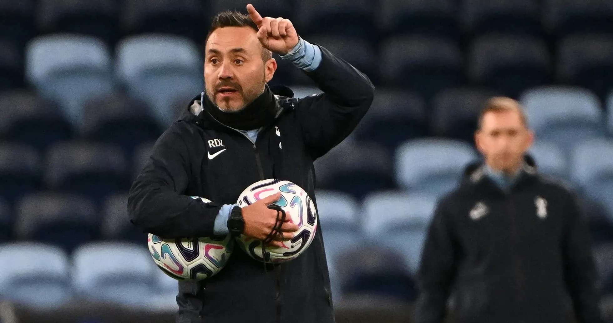 Entrenador dirigiendo a su equipo con balones