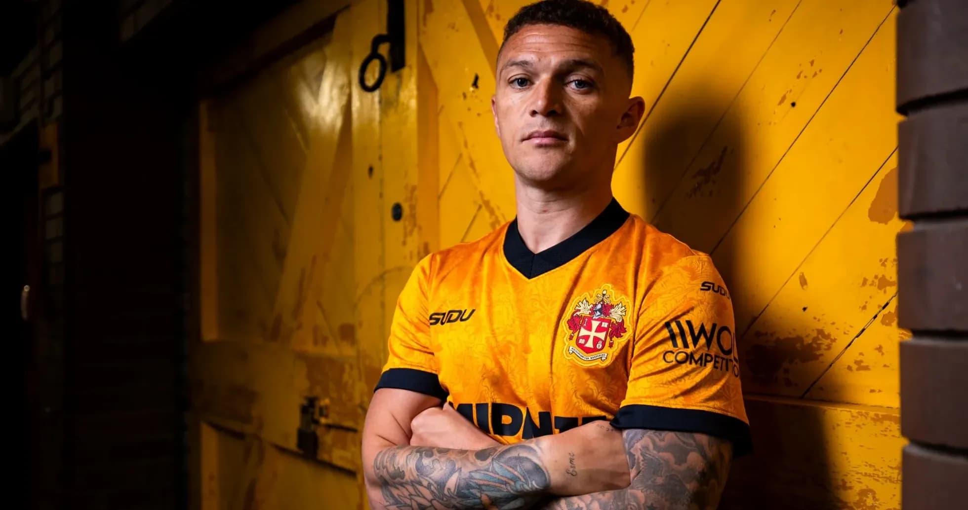 Jugador posando en camiseta amarilla frente a fondo amarillo