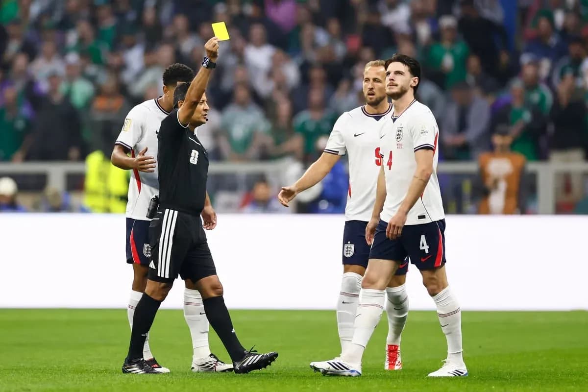 Árbitro mostrando tarjeta amarilla a un jugador