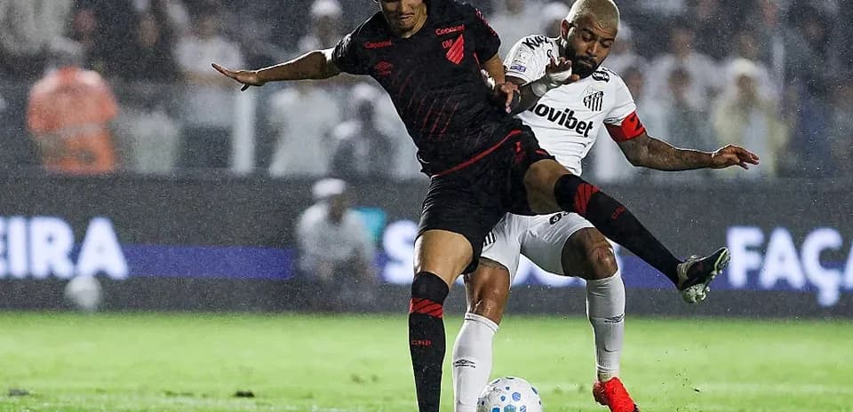 Jugadores luchando por el balón bajo la lluvia