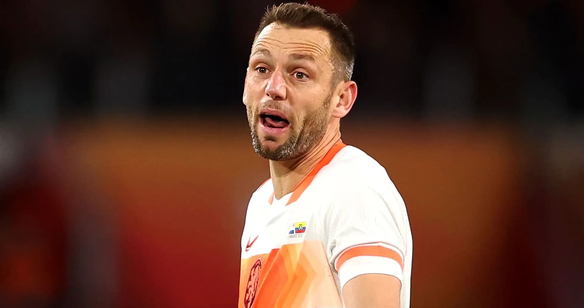 Jugador de fútbol con camiseta naranja en el campo