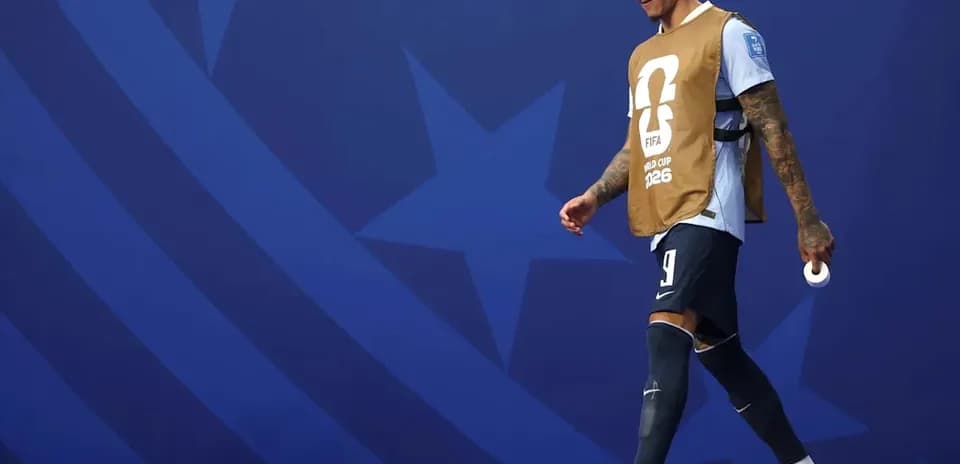 Jugador caminando con chaleco de calentamiento en el estadio
