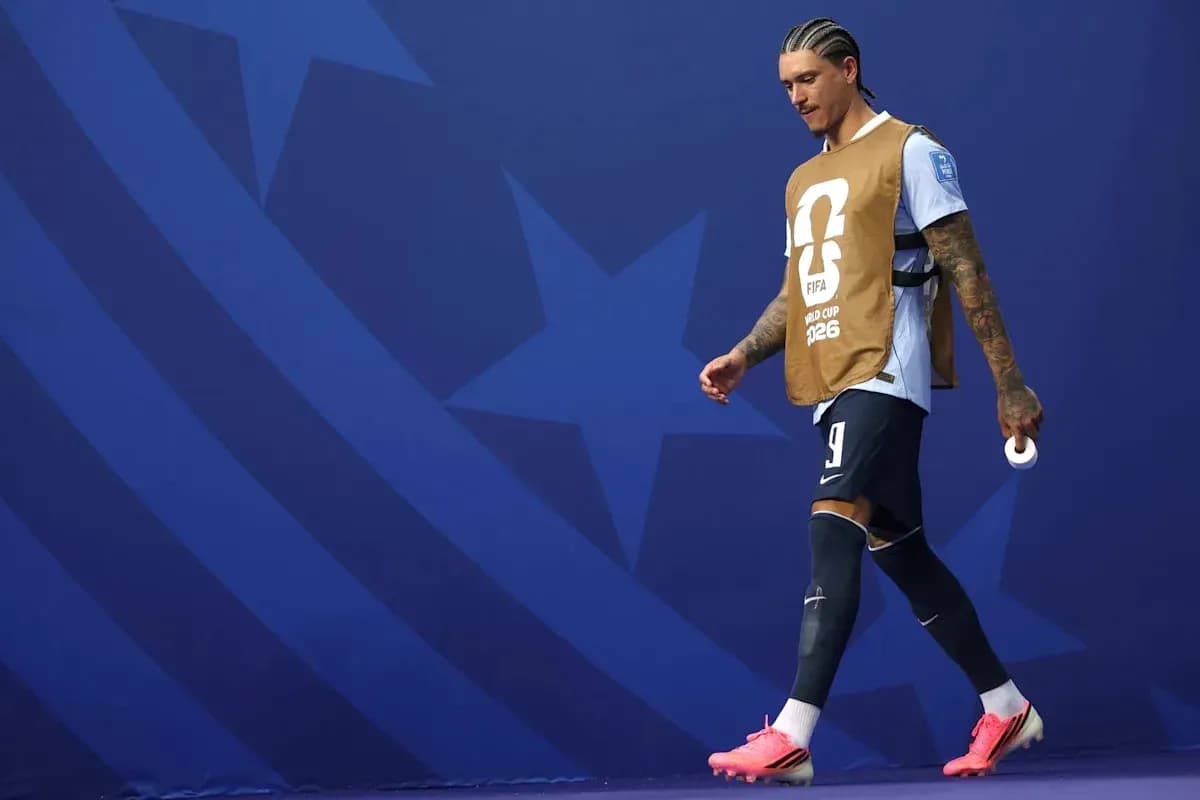 Jugador caminando con chaleco de calentamiento en el estadio