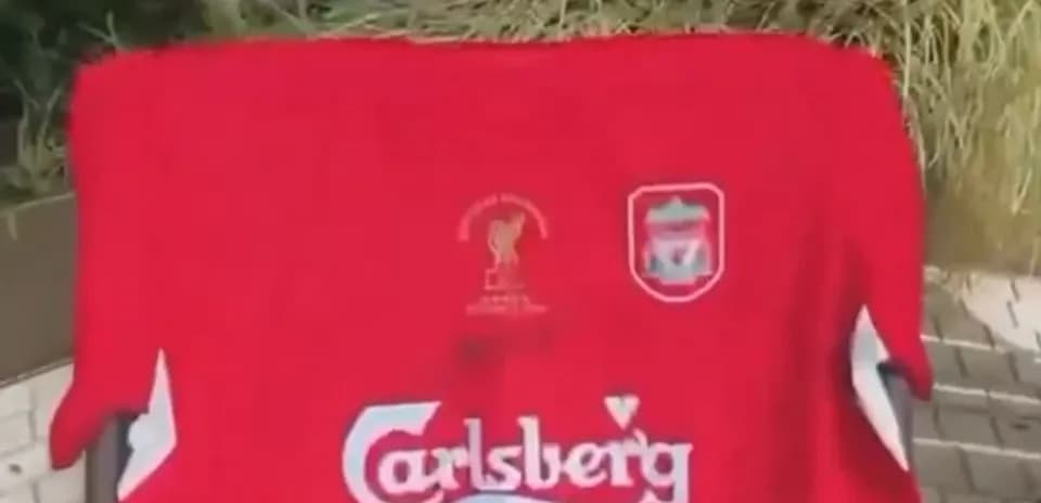 Camisa roja de Liverpool con logotipos y emblemas