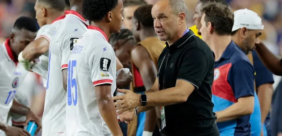 Entrenador hablando con jugadores de Haití