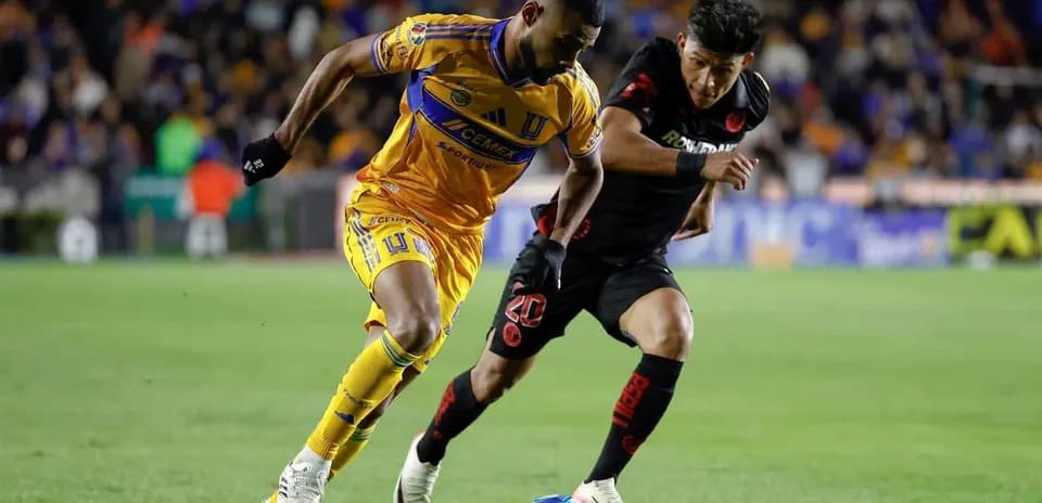 Jugador de Tigres UANL driblando a rival de Toluca