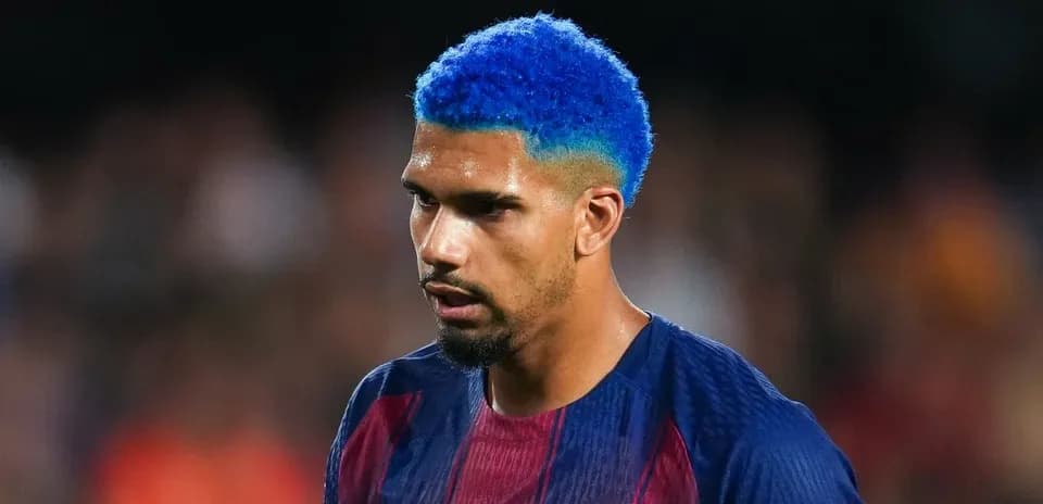 Jugador de fútbol con cabello azul en el campo