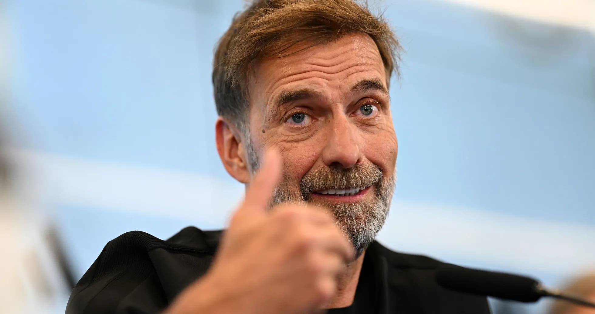 Entrenador hablando en conferencia de prensa con pulgar arriba