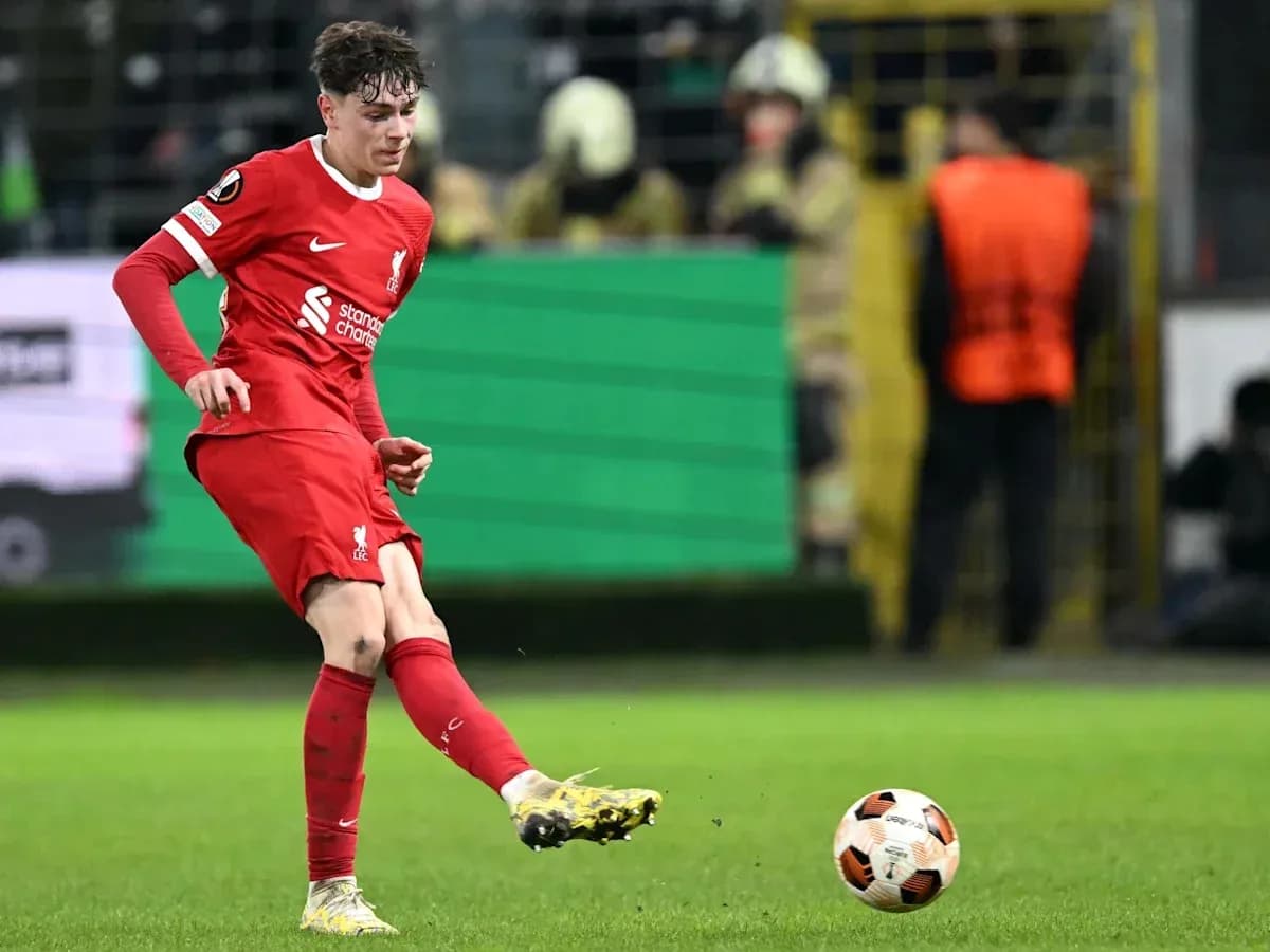 Jugador de Liverpool golpeando el balón en el campo