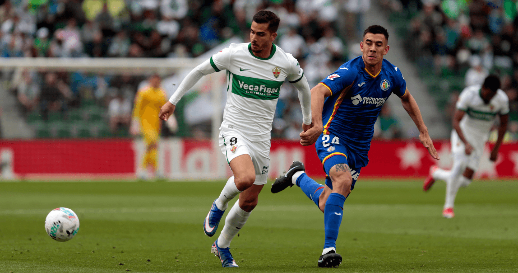 Jugadores de Elche y Getafe compiten por el balón