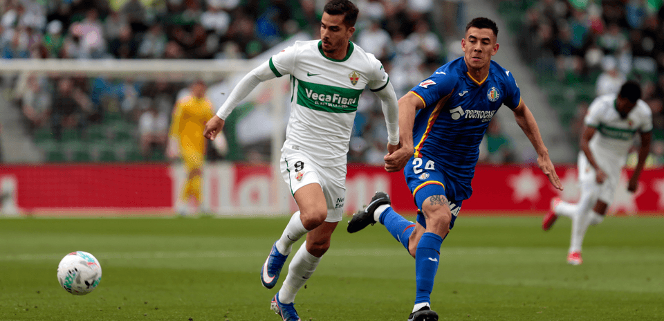 Jugadores de Elche y Getafe compiten por el balón