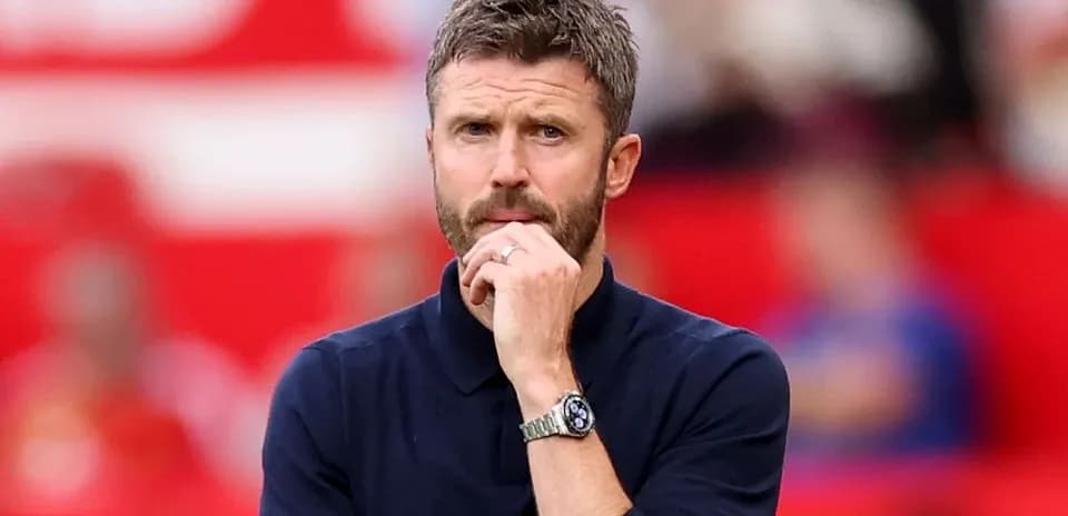 Entrenador observando el partido con expresión pensativa