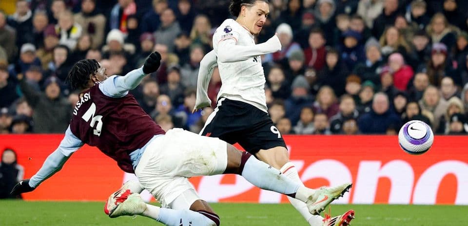 Jugador de Aston Villa intenta detener a Liverpool