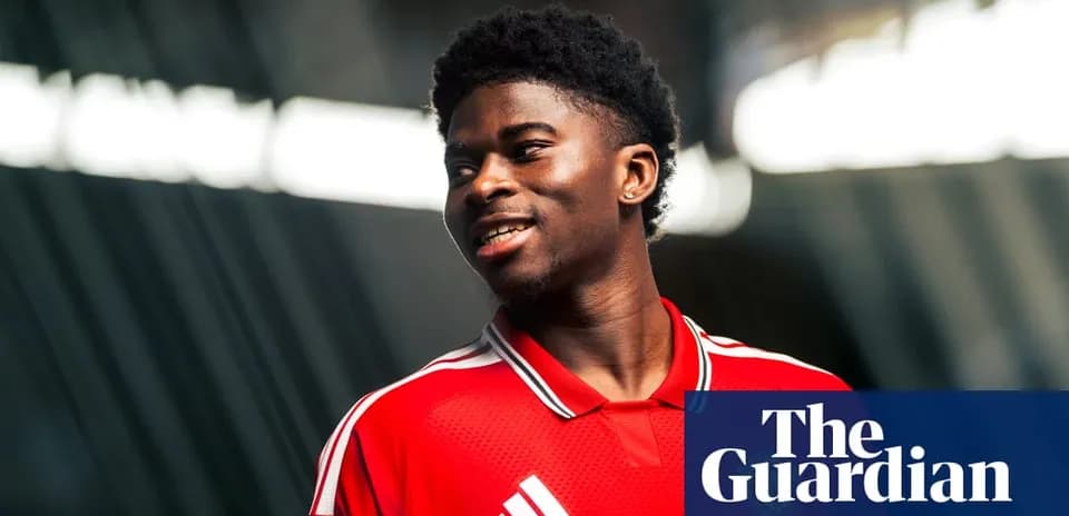 Jugador con camiseta roja sonriendo en sesión fotográfica