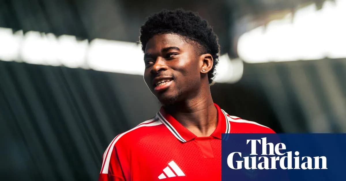 Jugador con camiseta roja sonriendo en sesión fotográfica