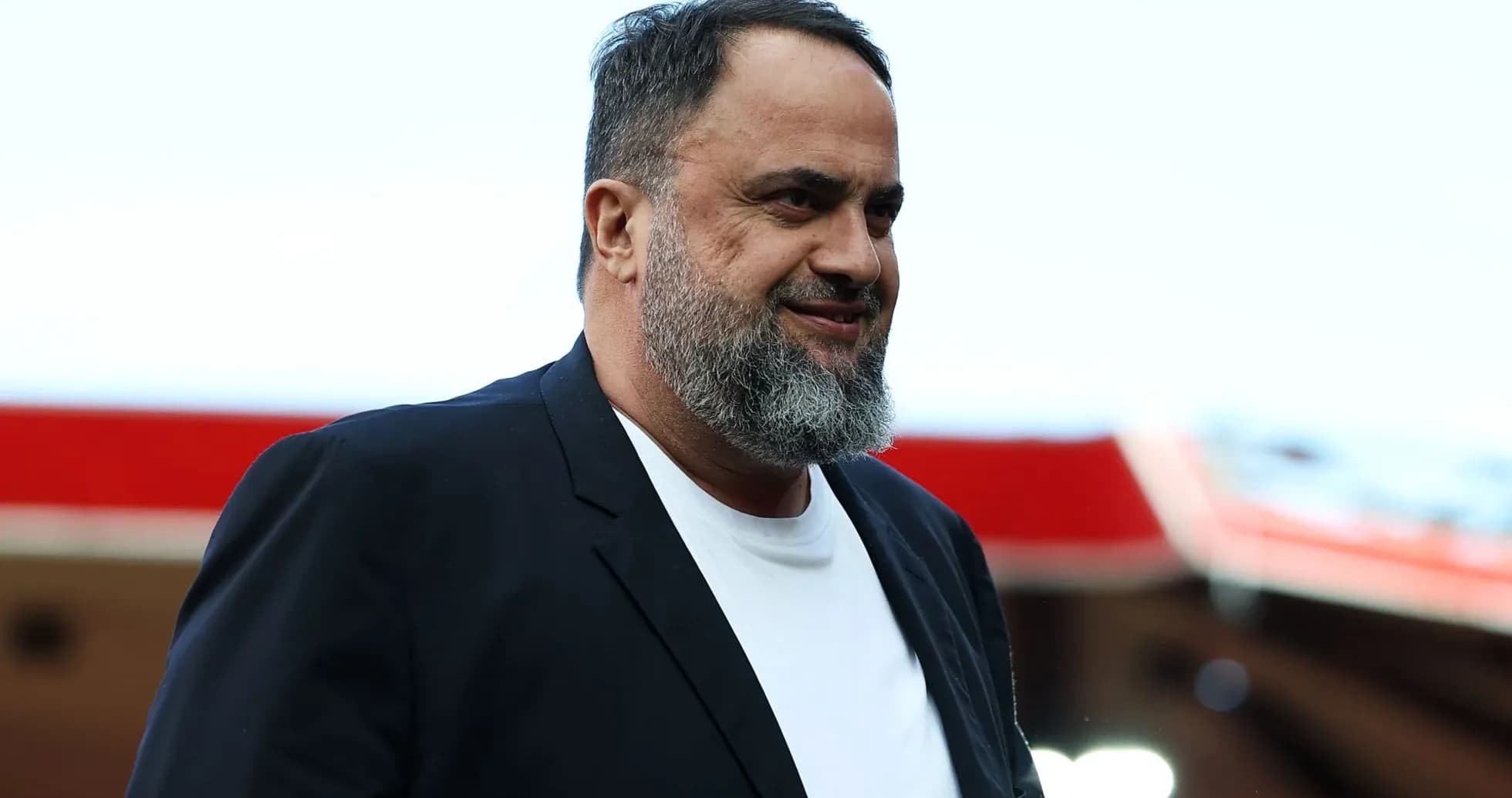 Hombre con barba vestido de traje en estadio