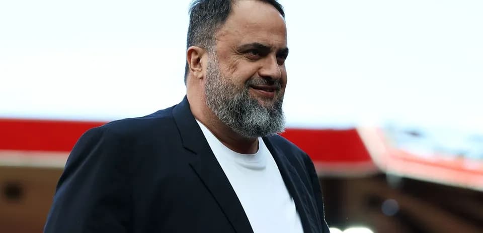 Hombre con barba vestido de traje en estadio