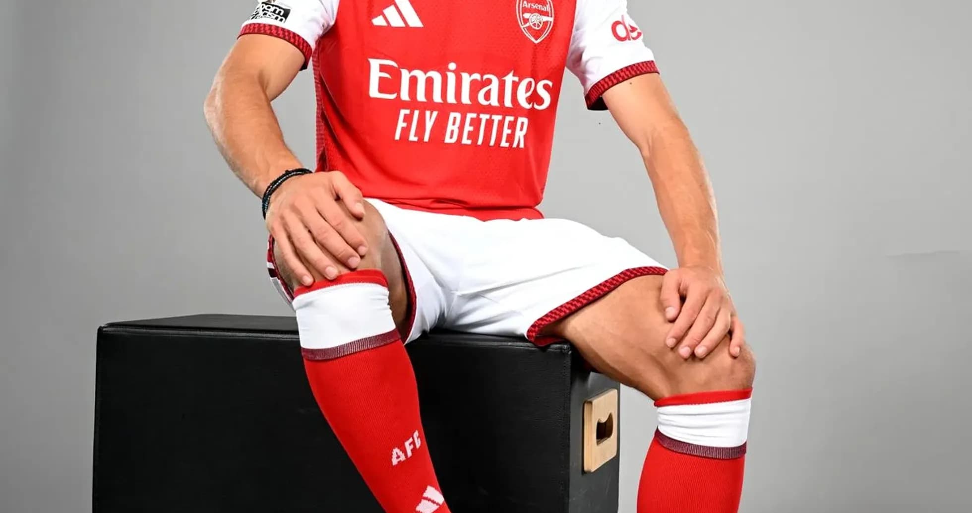 Jugador posando con camiseta del Arsenal y balón