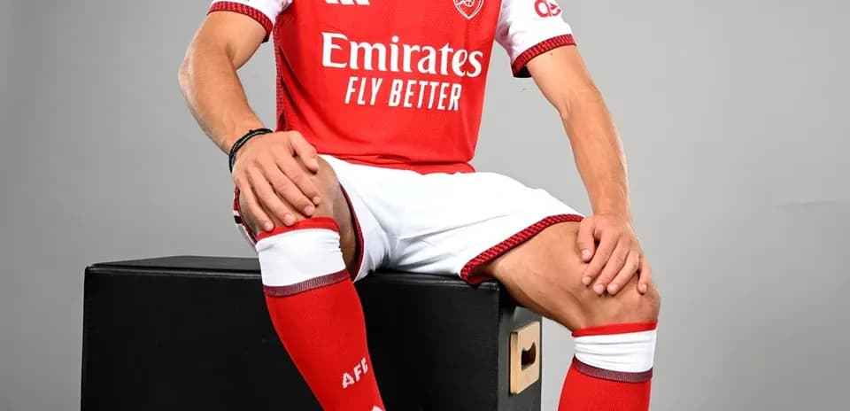 Jugador posando con camiseta del Arsenal y balón