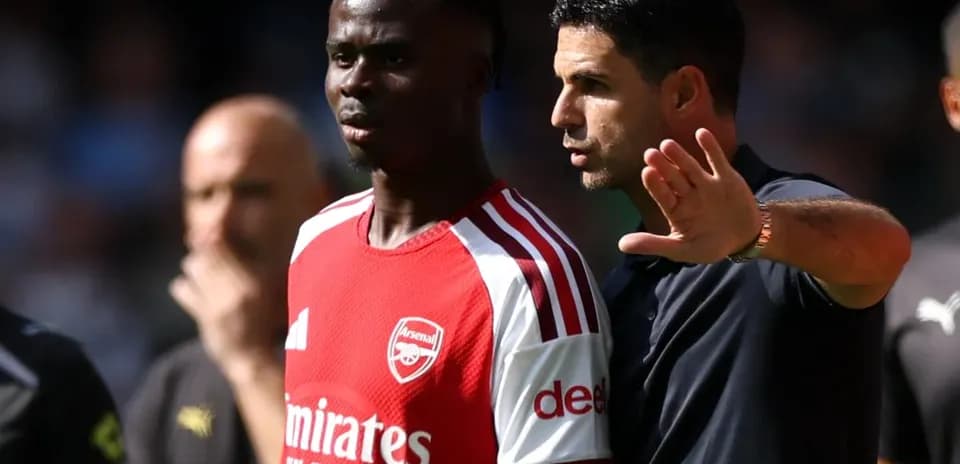 Entrenador hablando con jugador de Arsenal durante partido