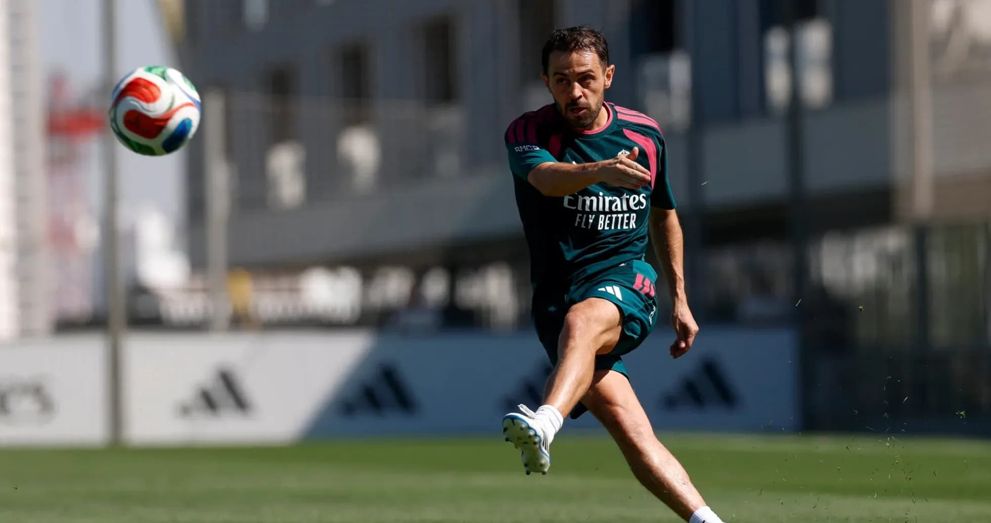 Jugador entrenando y pateando un balón en campo