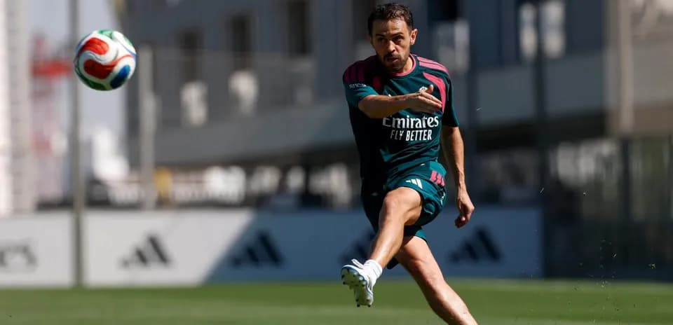 Jugador entrenando y pateando un balón en campo