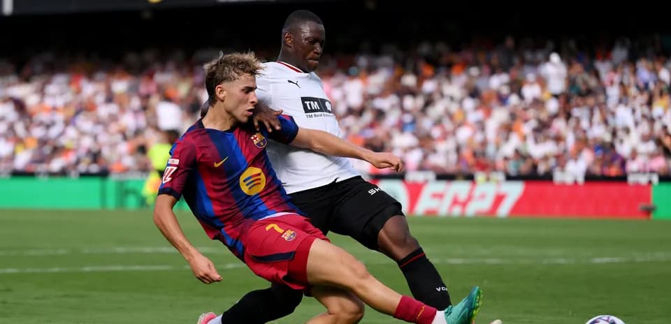 Jugador de Barcelona deslizándose para quitar el balón