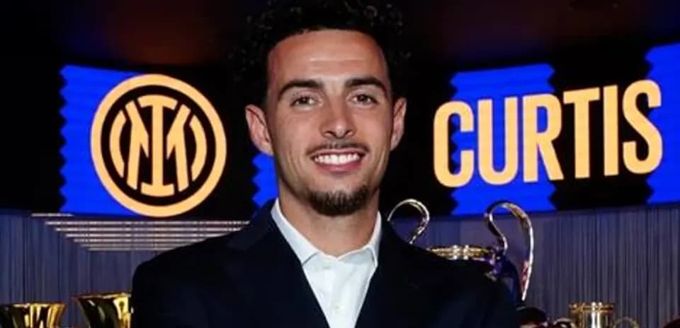 Jugador sonriente junto a trofeos de Inter de Milán