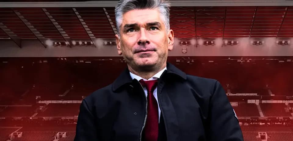 Entrenador posando frente a un estadio vacío