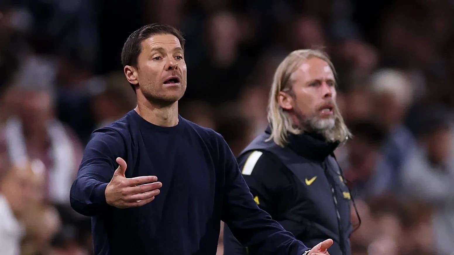 Entrenador gesticulando durante el partido en la línea lateral