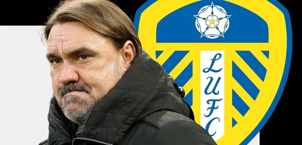 Entrenador de pie frente al escudo de Leeds United