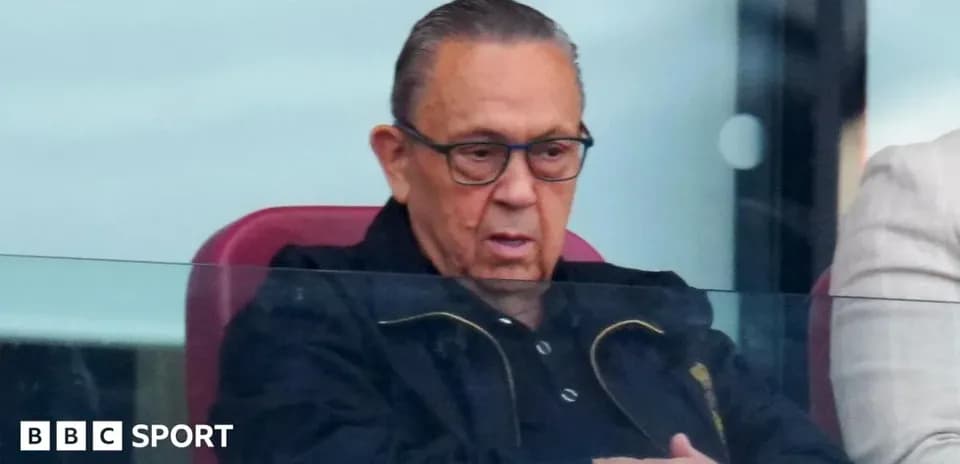 Hombre en palco observando un partido de fútbol