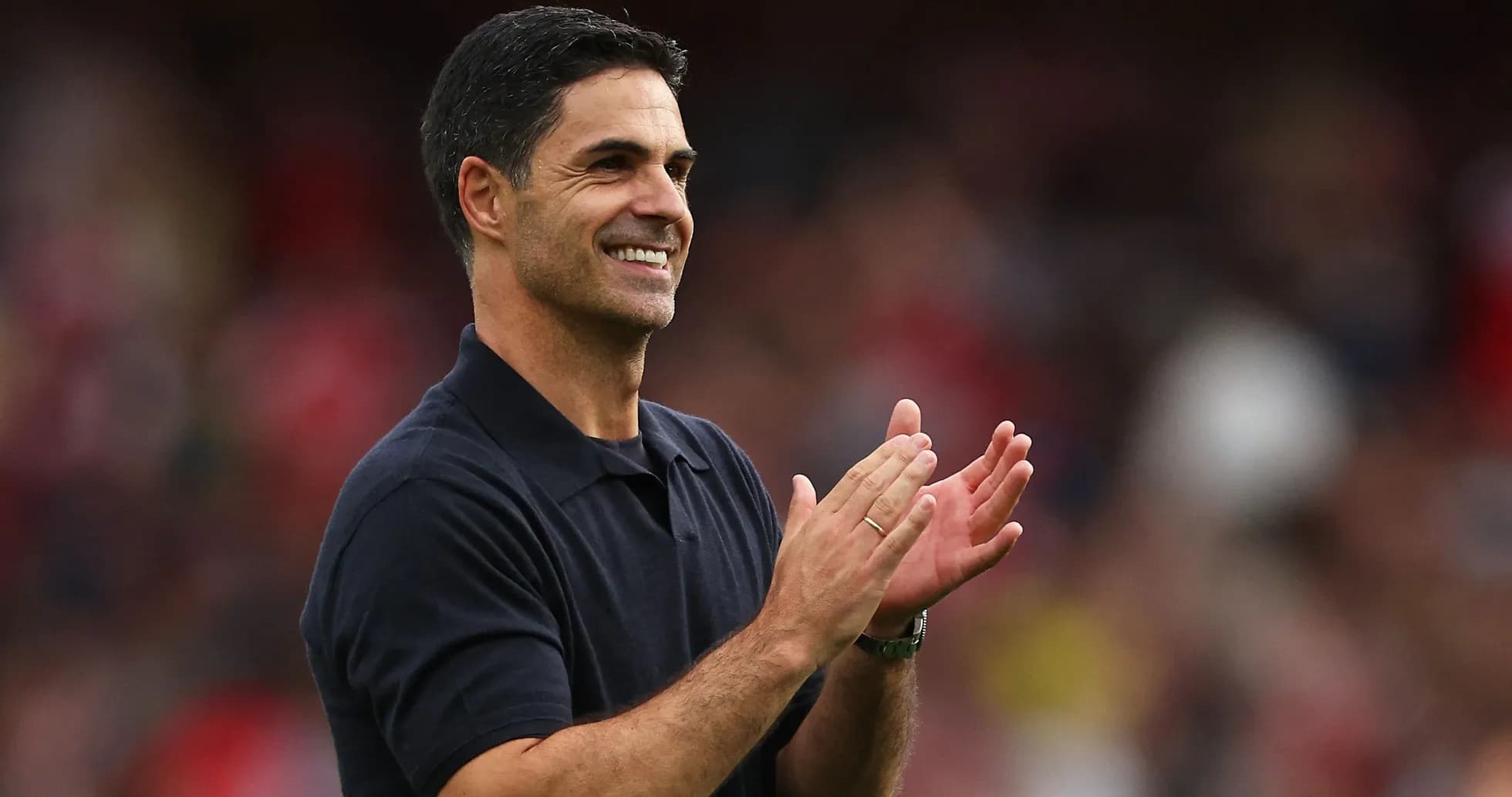 Entrenador aplaudiendo en el campo de fútbol