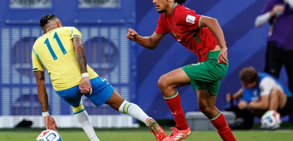 Jugador de Brasil esquivando a defensor de Marruecos